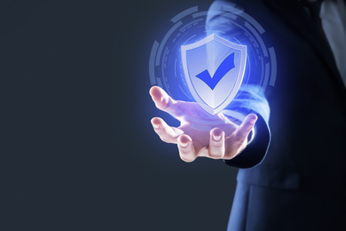 Cyber insurance concept. Man demonstrating shield illustration as symbol of protection, closeup