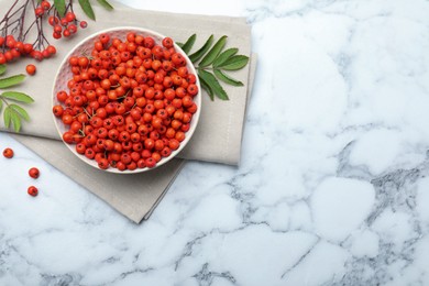 Fresh ripe rowan berries and leaves on white marble table, flat lay. Space for text