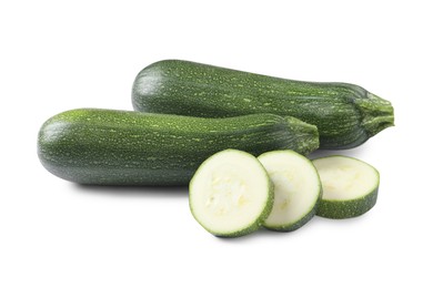 Whole and cut green ripe zucchinis isolated on white