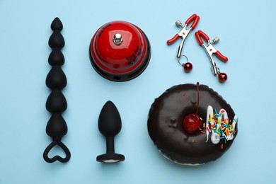 Photo of Flat lay composition with sex toys on light blue background