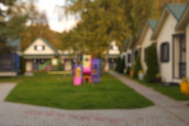 Beautiful houses and playground outdoors, blurred view. Real estate for rent