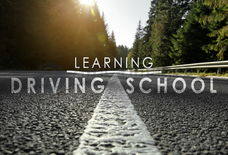 Driving school concept. Closeup view of asphalt road surrounded by forest on sunny day