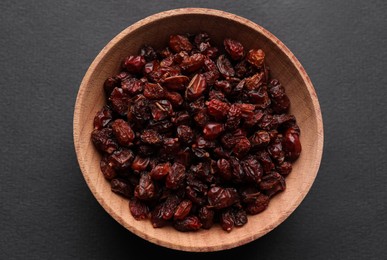 Dried barberries in wooden bowl on grey background, top view