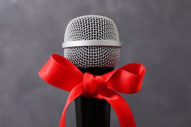 Microphone with red bow on grey background. Christmas music