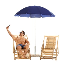 Photo of Young man taking selfie on sun lounger under umbrella against white background. Beach accessories