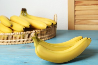 Ripe yellow bananas on light blue wooden table