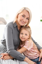 Photo of Cute little girl and her grandmother at home