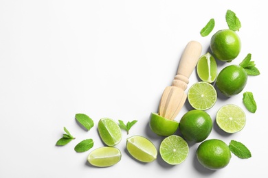 Flat lay composition with lime, mint and juicer on light background. Refreshing beverage ingredients
