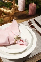 Stylish table setting with pink fabric napkin, beautiful decorative ring and festive decor, closeup