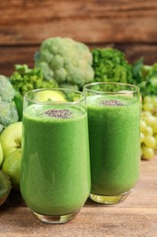 Glasses of fresh green smoothie on wooden table