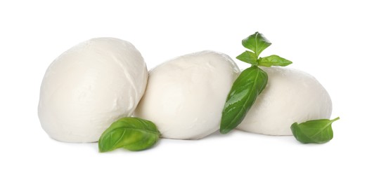 Delicious mozzarella cheese balls and basil on white background
