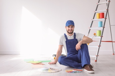 Male decorator with color palettes indoors