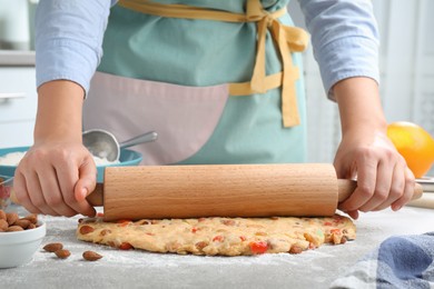 Woman rolling dough for Stollen at grey table, closeup. Baking traditional German Christmas bread