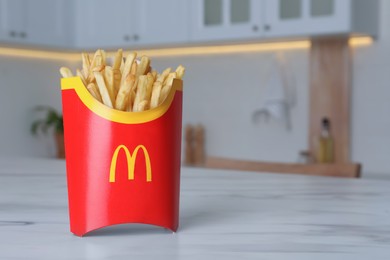 MYKOLAIV, UKRAINE - AUGUST 12, 2021: Big portion of McDonald's French fries on marble table in kitchen. Space for text