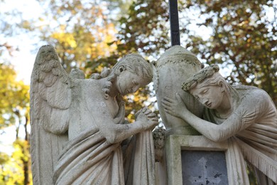 Photo of Beautiful statues of angels at cemetery. Religious symbol
