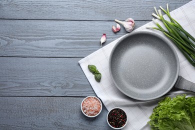 Photo of Flat lay composition with frying pan and fresh products on grey wooden table, space for text