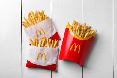 MYKOLAIV, UKRAINE - AUGUST 12, 2021: Small and big portions of McDonald's French fries on white wooden table, flat lay