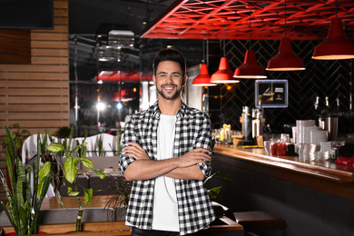 Photo of Young business owner standing in his cafe
