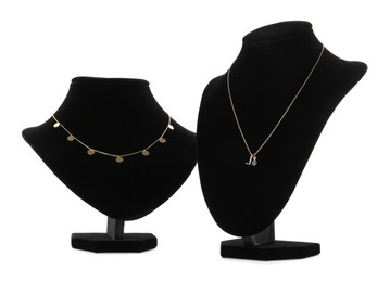 Stylish necklaces on jewelry busts against white background
