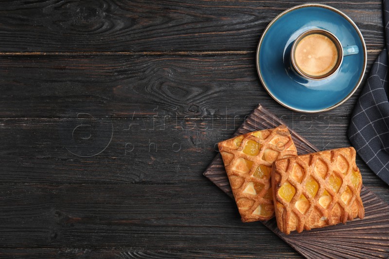 Photo of Delicious pastries and coffee on black wooden table, flat lay. Space for text