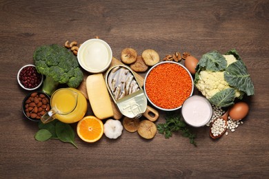 Photo of Set of natural food high in calcium on wooden table, flat lay