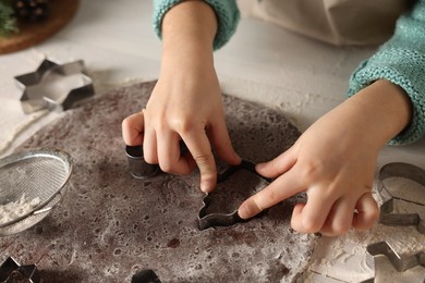 Little child making cookies at white wooden table, closeup
