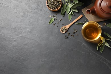 Flat lay composition with aromatic sage tea on black table. Space for text