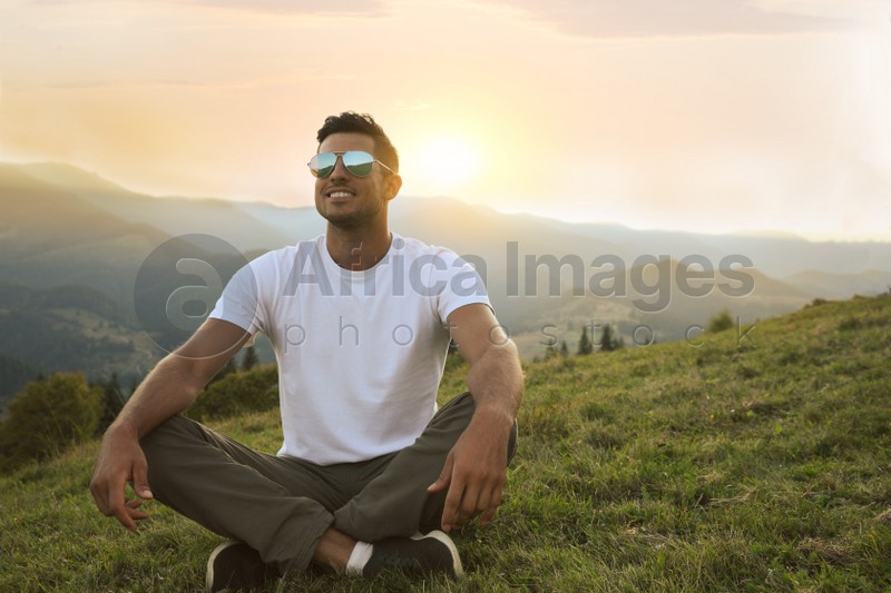 Photo of Handsome man enjoying beautiful mountain landscape at sunset