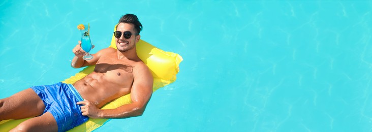 Young man with cocktail and inflatable mattress in swimming pool on sunny day. Banner design