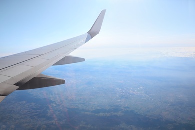 Airplane flying in sky, view on wing. Air transportation