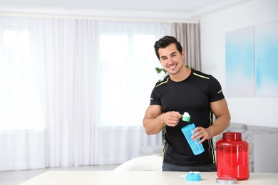 Young athletic man preparing protein shake at home, space for text