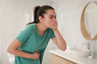 Young woman suffering from nausea in bathroom. Food poisoning