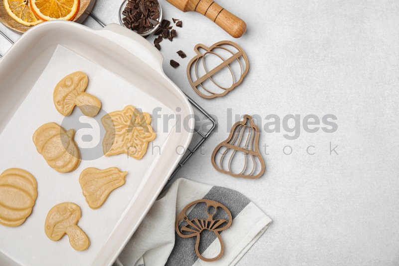 Photo of Flat lay composition with cookie cutters and dough on light table. Space for text