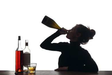 Alcohol addiction. Woman drinking sparkling wine from bottle on white background