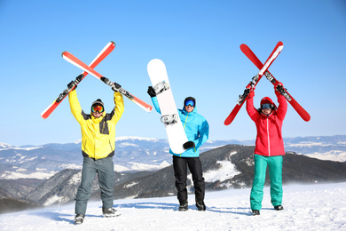 Photo of Friends with equipment at ski resort. Winter vacation