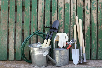 Set of gardening tools near wooden fence