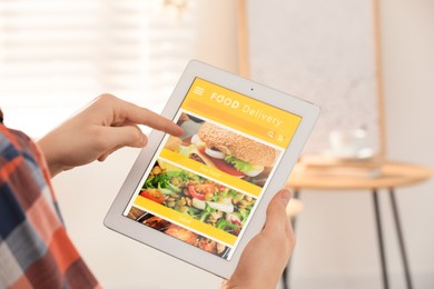 Man using tablet for ordering food online at home, closeup. Concept of delivery service