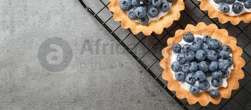 Delicious sweet pastry with blueberries on grey table, top view with space for text. Banner design
