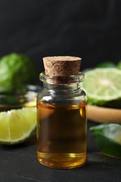 Bottle of bergamot essential oil on dark table, closeup
