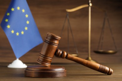 Judge's gavel, scales of justice and European Union flag on wooden table