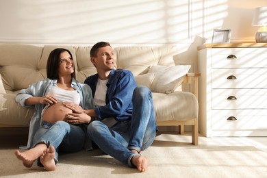 Young pregnant woman with her husband at home
