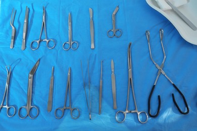 Different surgical instruments on blue table, flat lay