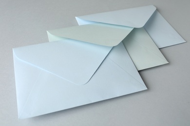 White paper envelopes on light grey background, closeup. Mail service