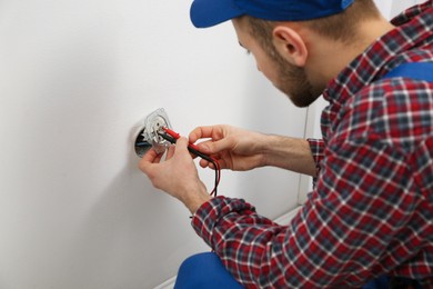 Electrician with tester checking voltage, closeup view