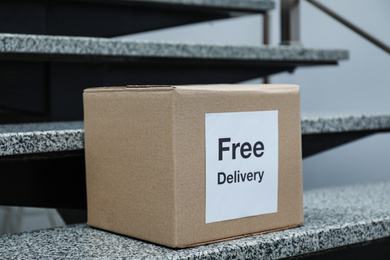 Parcel with sticker Free Delivery on stairs. Courier service