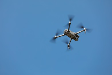 Modern drone against blue sky, low angle view. Space for text