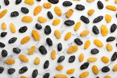 Flat lay composition with raisins on marble background. Dried fruit as healthy snack