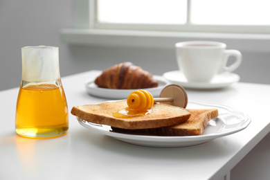 Delicious honey and toasts on white table