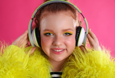 Cute indie girl with headphones on pink background