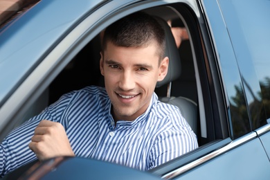 Attractive young man in modern luxury car
